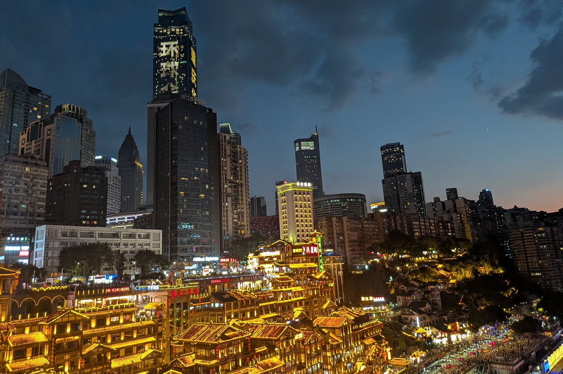 Illuminated Hongya Cave buildings above the waterfront in Chongqing, photographed during the author’s trip.